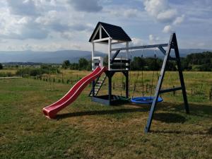 a playground with a slide in a field at Pokoje Gościnne Karkonosze in Wojcieszyce