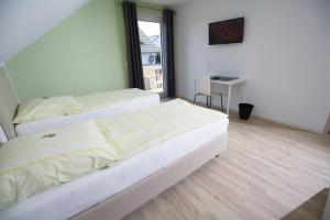- 2 lits dans une chambre avec fenêtre dans l'établissement Hotel am Baronenwald, à Göppingen