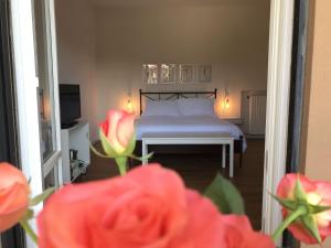 a bedroom with a bed and a window with red roses at Pisacane61 B&B in Modena