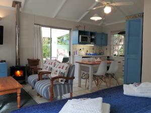 ein Wohnzimmer mit einem Sofa und einem Tisch sowie eine Küche in der Unterkunft Eastbury Cottage in Hermanus