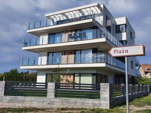 a tall building with a sign in front of it at Apartament Azure 19 - 365PAM in Kołobrzeg