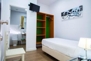 a small bedroom with a bed and a bathroom at Hostal San Francisco in Seville