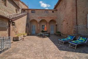 a courtyard with chairs and tables in an old building at Agriturismo La Ripolina in Buonconvento
