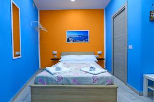 a bedroom with a bed with blue and orange walls at Da Zia Geppina in Naples