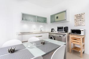 a kitchen with a table and a sink and a microwave at Casa Sirena in Santa Cruz de Tenerife