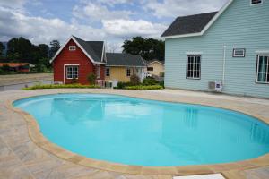 a large blue swimming pool in front of a house at Evie Mae Resort in Ban Cha-om