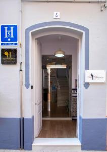 una entrada a un edificio con una puerta azul y blanca en Hostal San Francisco, en Sevilla