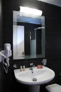 bagno con lavandino, specchio e servizi igienici di Hotel Pegasos a Nikiana