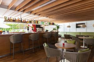 a restaurant with tables and chairs and a bar at Aimia Hotel in Port de Soller