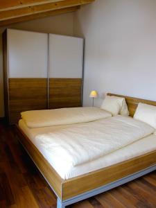 a bedroom with a large bed with a wooden headboard at Bergquelle Dachwohnung in Bettmeralp