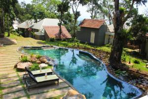 a swimming pool with a bench next to a house at SpiceTree Rajakumari in Munnar