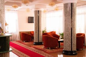 a hotel lobby with chairs and columns at Altyn Dala Hotel in Astana