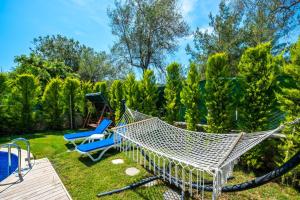 a hammock and two chairs in a yard at TERRA PİNE in Kayakoy