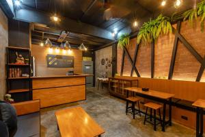 un restaurante con mesas de madera y un bar en The Z Nite Hostel, en Phuket