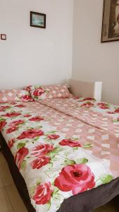 a bed with a pink and white blanket with flowers on it at Ferienwohnung Angelina in Markdorf