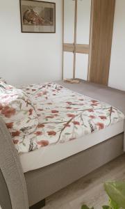 a bedroom with a bed with a floral bedspread at Ferienwohnung Angelina in Markdorf