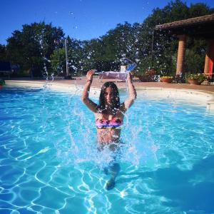 een meisje is in een zwembad met water bij Villa Antares in Pesaro