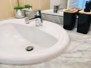 a white sink in a bathroom with two trash cans at South West in Anglet +21 photos