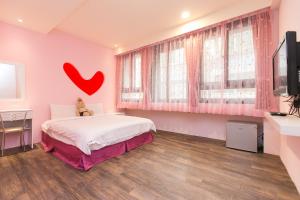 a bedroom with a bed with a heart on the wall at Amir B&B train station & elevator with parking lot in Hualien City