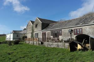 an old stone house with a yard in front of it at Trimstone Manor Hotel in West Down