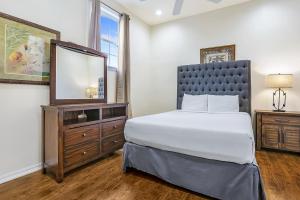 Un dormitorio con una cama, una cómoda y un televisor. en Modern 4BR Penthouse in Downtown by Hosteeva, en Nueva Orleans