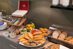 a buffet with various types of bread and other foods at Sporthotel Bruurs in Baarle-Nassau