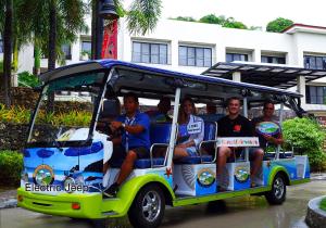 a group of people sitting in a golf cart at Fairways and Bluewater Boracay in Boracay
