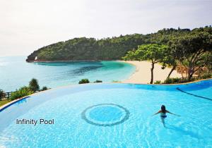 a woman swimming in a infinity pool next to a beach at Fairways and Bluewater Boracay in Boracay