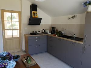 una cucina con armadi grigi, un lavandino e una finestra di maison entre campagne et mer a Plonéour-Lanvern