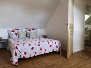 una camera con un letto e un piumone rosso e bianco di maison entre campagne et mer a Plonéour-Lanvern