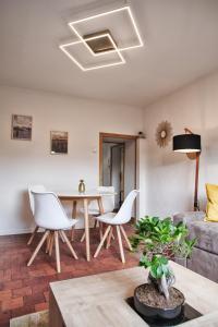 ein Wohnzimmer mit einem Tisch, Stühlen und einem Sofa in der Unterkunft Le Petit Porte Guillaume in Chartres