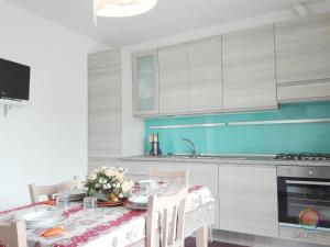 una cucina con tavolo da pranzo blu di Perle Del Mare - Appartamenti di Pregio 70m spiaggia Pescoluse a Marina di Pescoluse