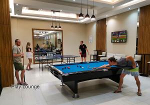 a group of people playing pool in a room at Fairways and Bluewater Boracay in Boracay