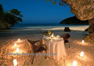 a dinner table on the beach with candles at Fairways and Bluewater Boracay in Boracay