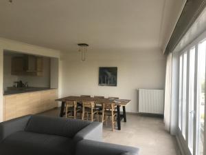 Il comprend un salon avec une table et une cuisine. dans l'établissement Apartment Thalassa5@sea, à Ostende