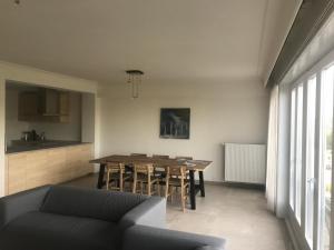 a living room with a table and a kitchen at Apartment Thalassa5@sea in Ostend