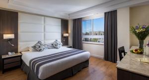Un pat sau paturi într-o cameră la Ambassador Hotel