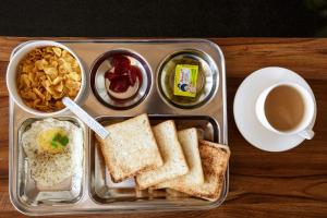 HITCHHIKERS HOSTEL LADAKH في ليه: صندوق غداء مع سندويشات وكوب من القهوة