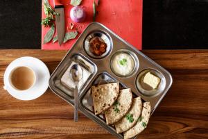 a tray with sandwiches and dips and a cup of coffee at HITCHHIKERS HOSTEL LADAKH in Leh