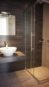 a bathroom with a sink and a glass shower at Paraporti in Chora Folegandros