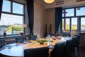 a conference room with a table and chairs and windows at Waxholms Hotell in Vaxholm