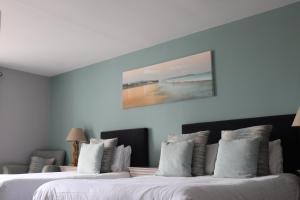 duas camas num quarto de hotel com um quadro na parede em Causeway Hotel em Bushmills