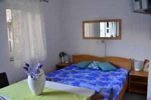 een slaapkamer met een bed en een vaas met bloemen op een tafel bij Apartment Kaštilac in Kaštela