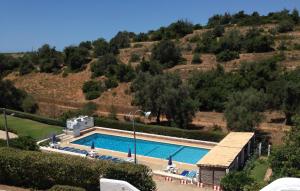 a large swimming pool in front of a hill at Casa Pura Vida - fantastic sea view in Pêra
