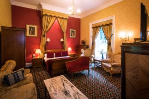 ein Schlafzimmer mit roten Wänden, einem Bett und einem Stuhl in der Unterkunft Oranmore in Ballymena