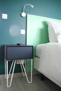 a television on a side table next to a bed at The View in Francorchamps