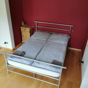 a bed in a room with a red wall at Bella Villa in Traben-Trarbach