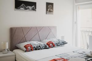 łóżko z szarym zagłówkiem i poduszkami w obiekcie Apartment Andreja, Opatija city center w mieście Opatija