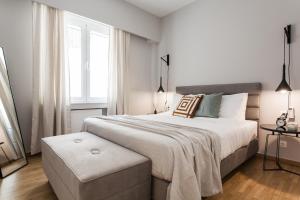 Un dormitorio blanco con una cama grande y una ventana en Peaceful 2BD Apartment in Kolonaki by UPSTREET en Atenas