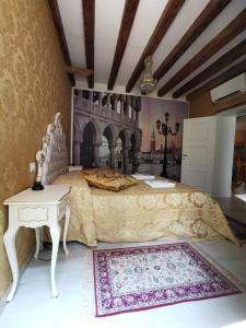 una camera con un grande letto con un tavolo e un letto sidx sidx di La Residenza di Carlo close to Piazza San marco a Venezia